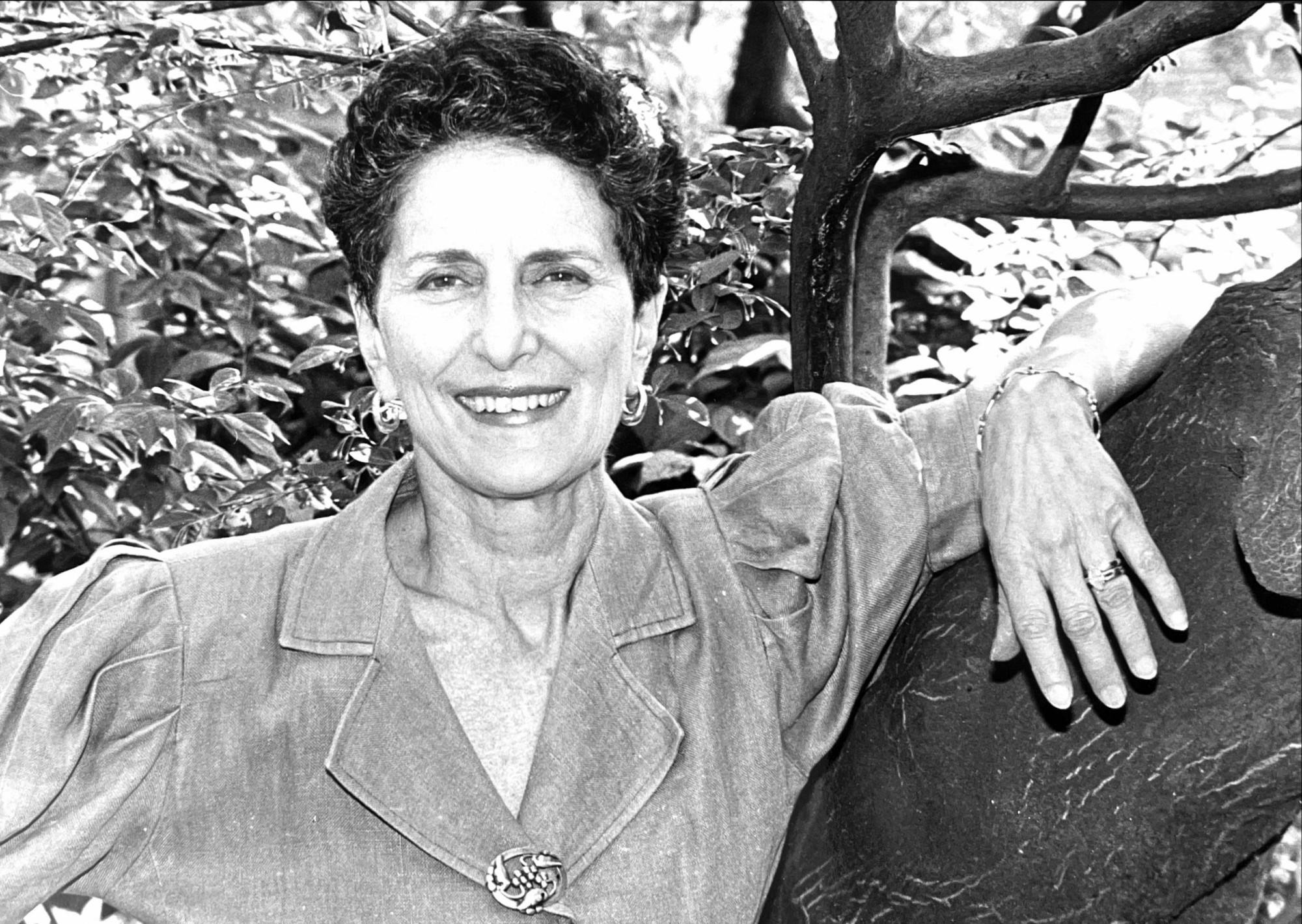Black and white photo of Natalie Zemon Davis posing in front of the tree. 