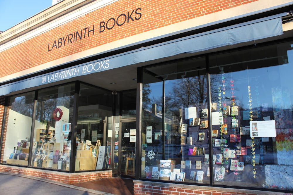 A storefront with "Labyrinth Books" printed across a blue awning. Books and strings of paper cranes are displayed in the windows.