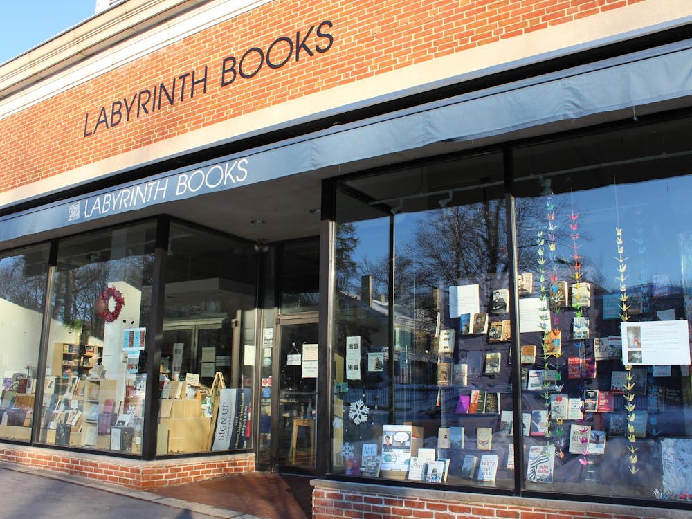 A storefront with "Labyrinth Books" printed across a blue awning. Books and strings of paper cranes are displayed in the windows.