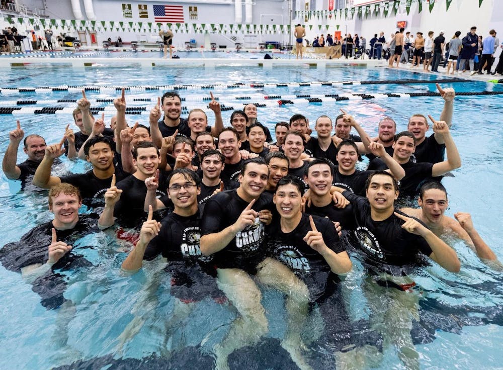 A group of men in the water holding up one sign after winning a championship.