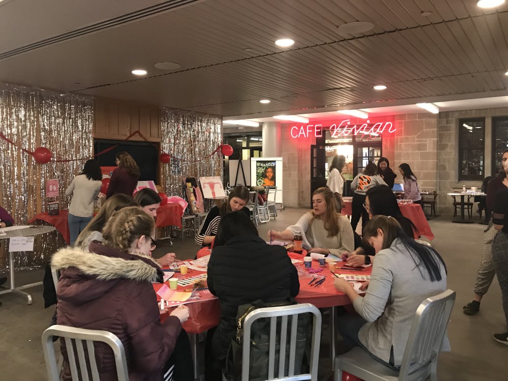<p>People taking advantage of the watercolor painting station and the fun food at the Menstruation Celebration on Friday. Photo by Marissa Michaels.</p>