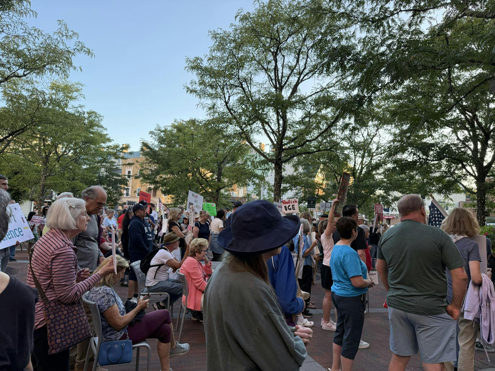 Community members hold signs with messaging against ICE actions. 
