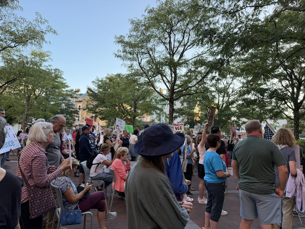 Community members hold signs with messaging against ICE actions.