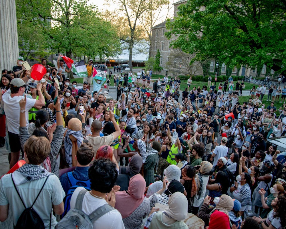 A large crowd of people cheering on and around the steps of a building.