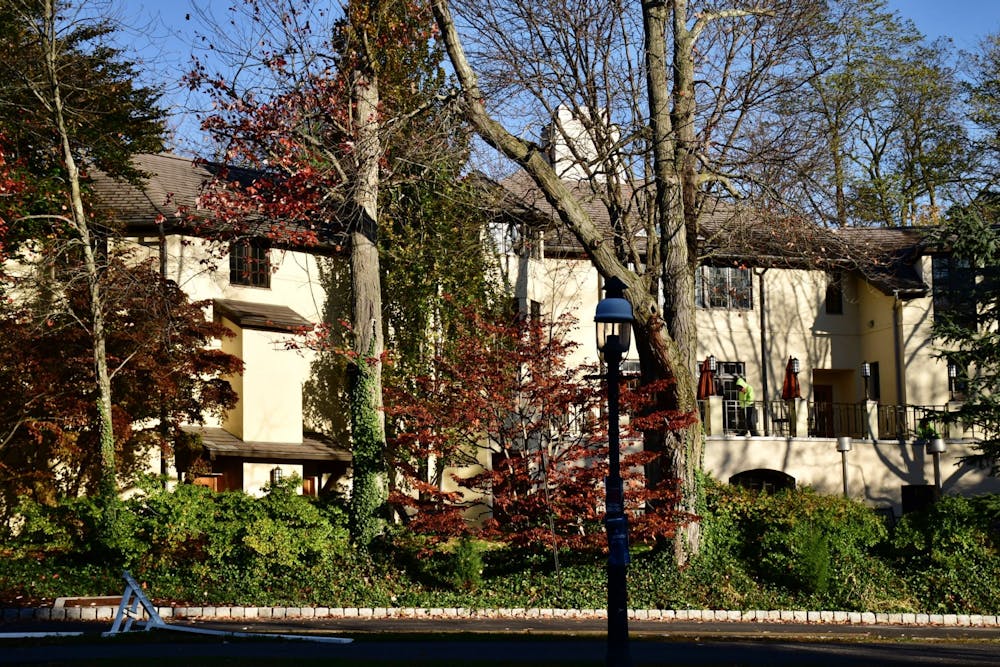 A building with trees and a lamppost in the foreground.