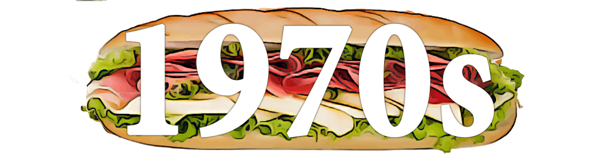 A large hoagie sandwich with the text "1970s" overlaid in white.