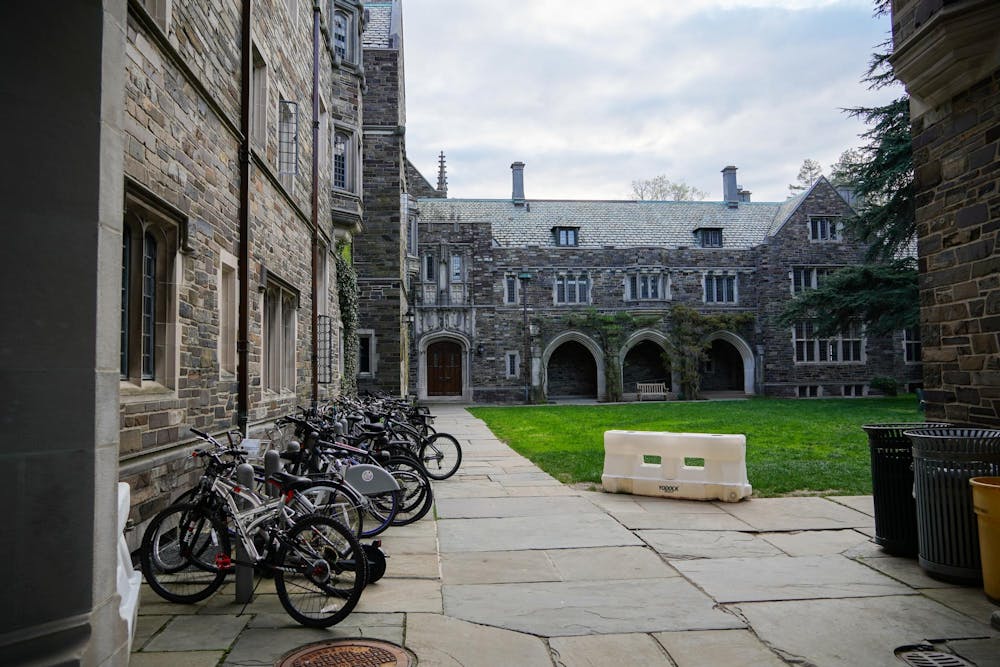 A photo of a collegiate gothic courtyard with many bicyles lined up on the left hand side.
