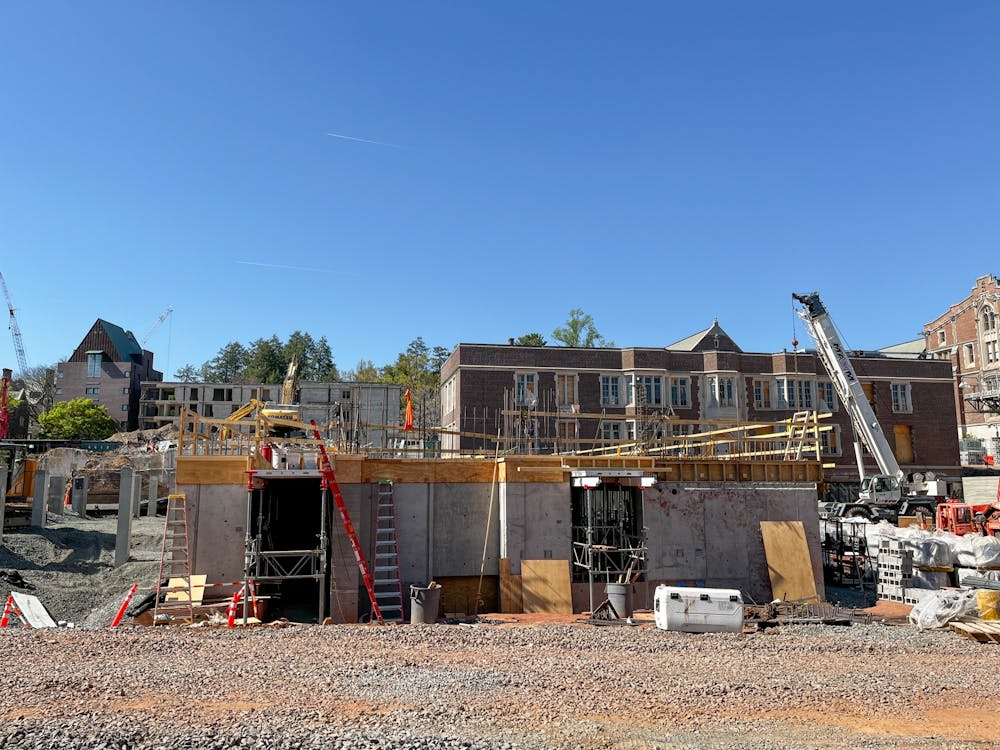 Ladders lean against the stone foundation of a building under construction