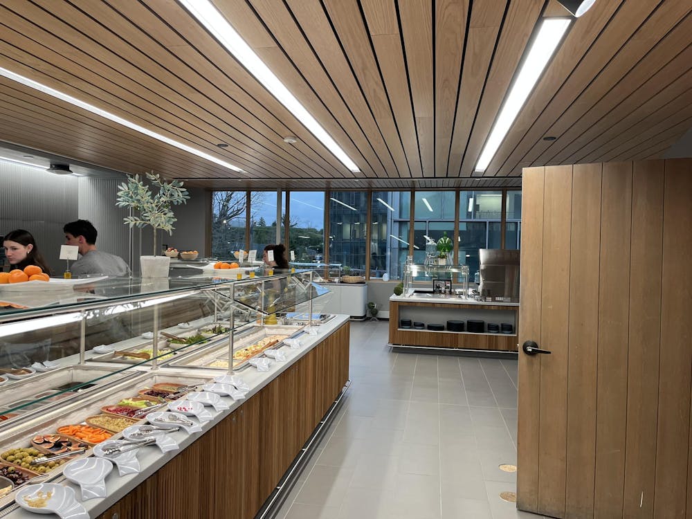 A room with a wooden ceiling and door on the right. A glass window in the background. There are trays with food on the left.