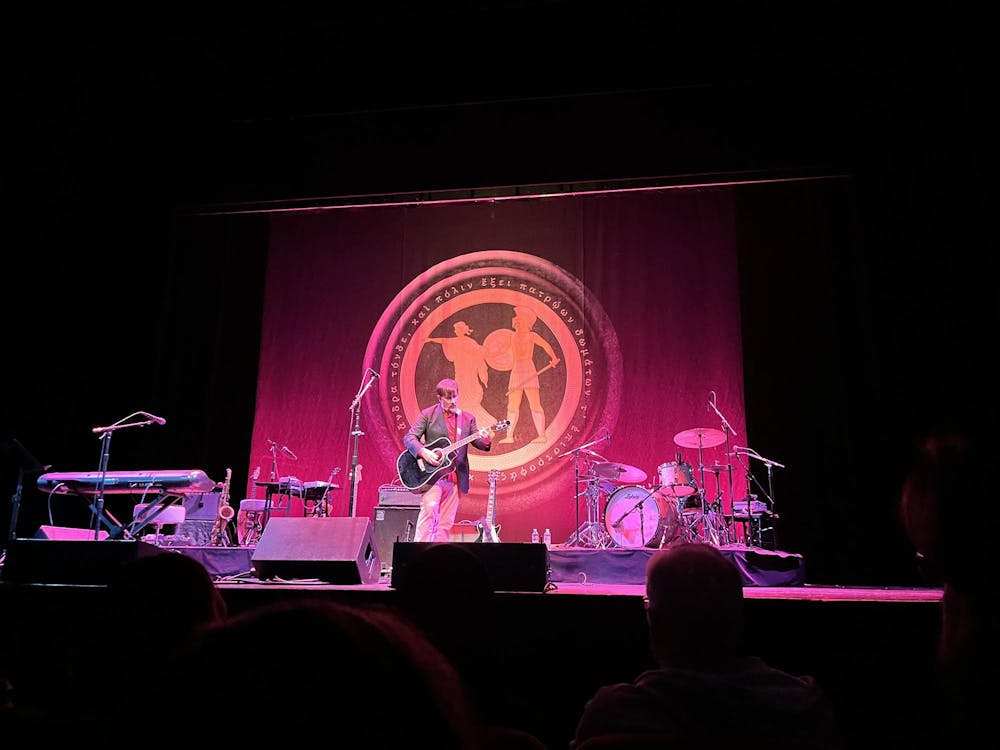 An individual plays a guitar on stage.