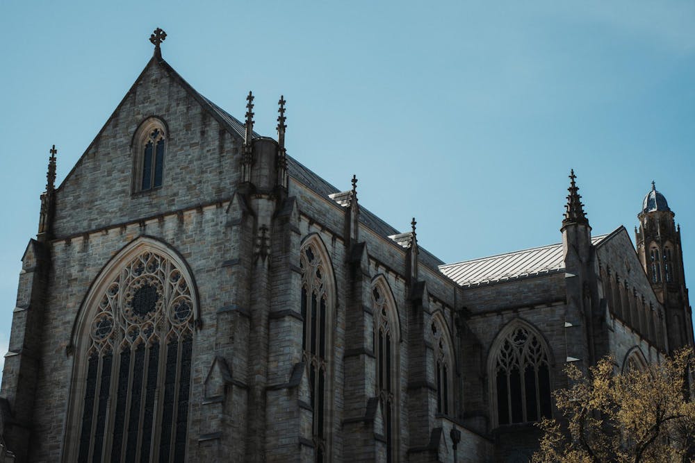 A gothic building stands in front of a blue sky.