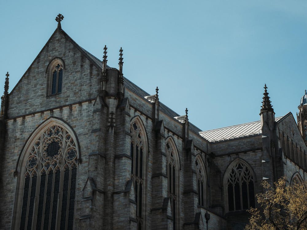 A gothic building stands in front of a blue sky.