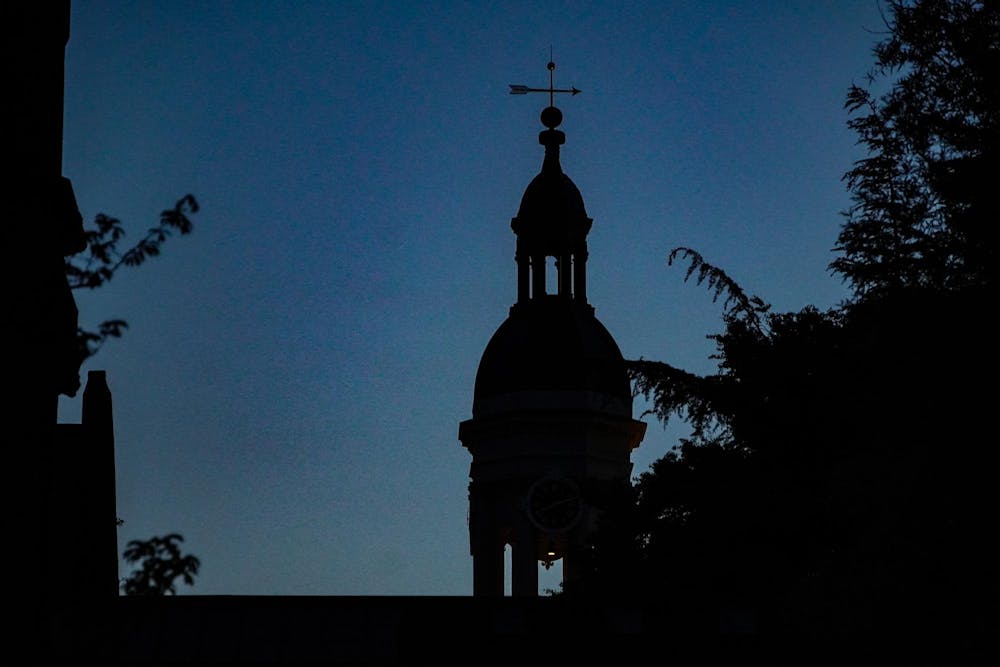 A silhouette of steeple with spire in the dark.