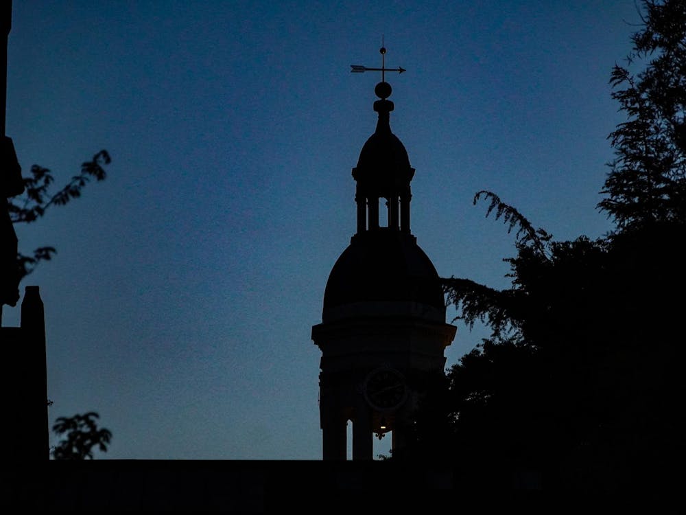 A silhouette of steeple with spire in the dark.