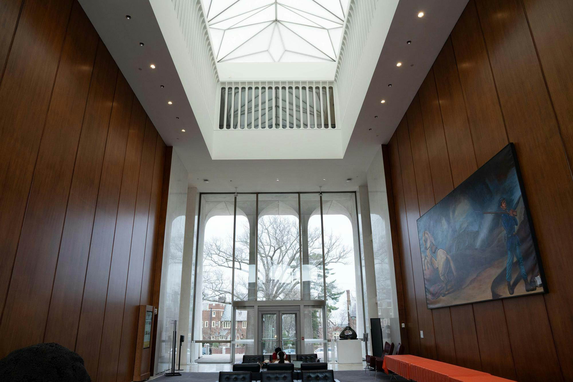 A large open room. There are windows in the roof and the front wall. On the right wall, there is a large painting.