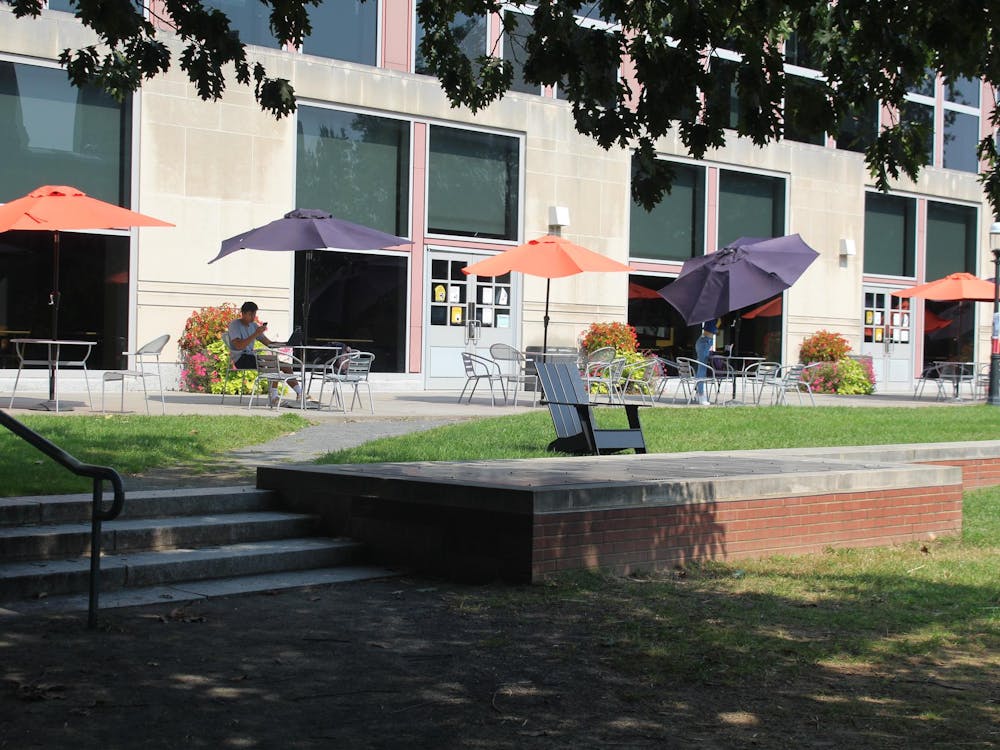 Patio with orange and purple umbrellas over metal tables and chairs.