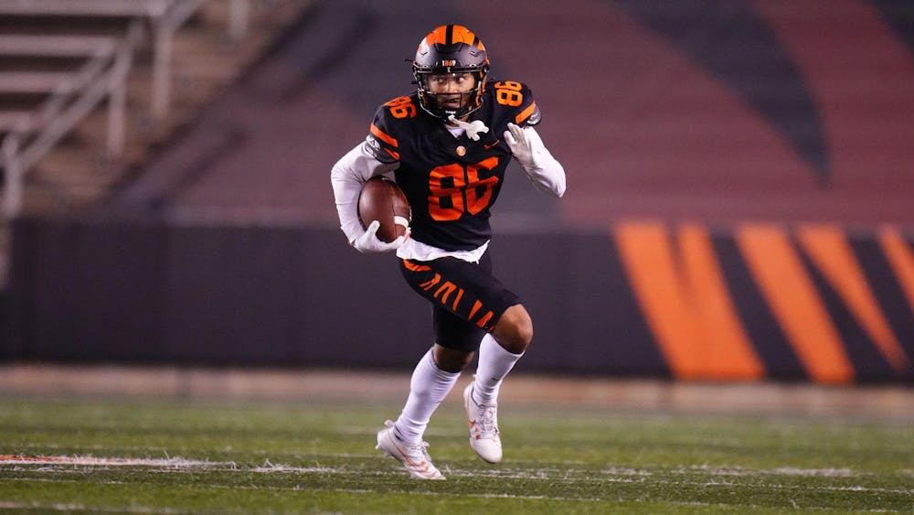 Man in black jersey runs down field with football.