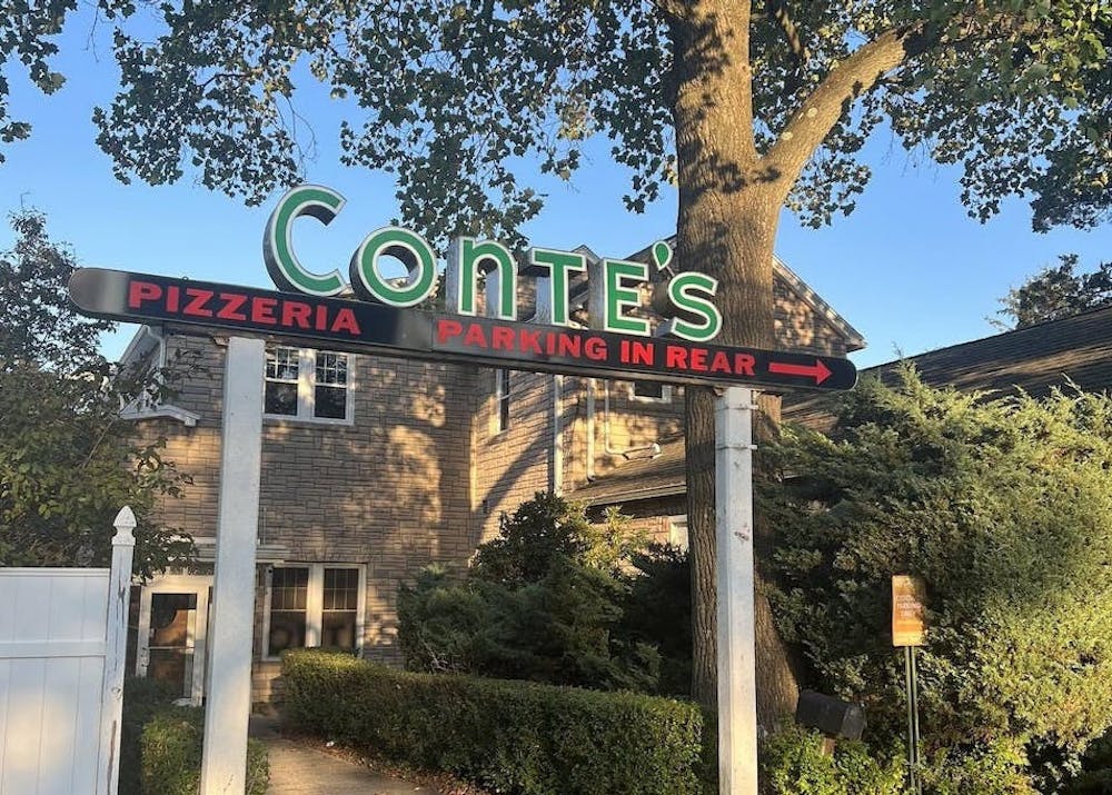 Conte's Pizzeria sign outside of the building during the day. 
