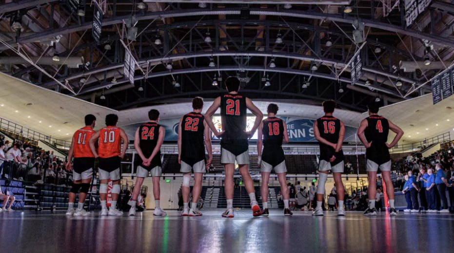 Men’s volleyball players lined up across the court.