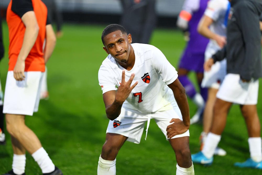 A man wearing a white jersey puts up three fingers. 