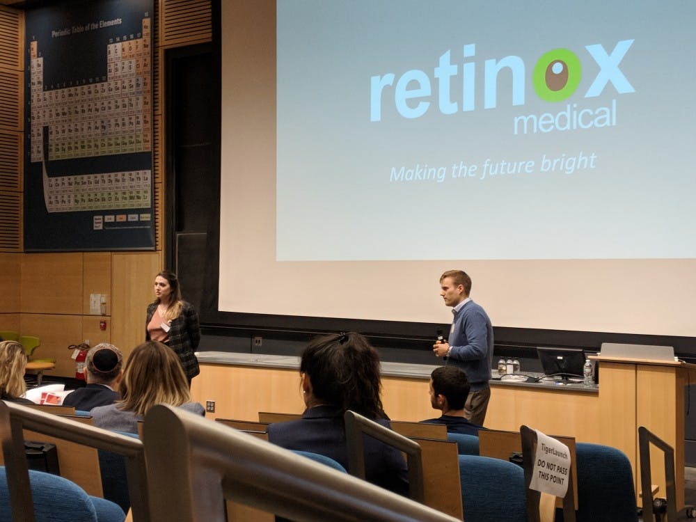 Two students present their company in a lecture hall.