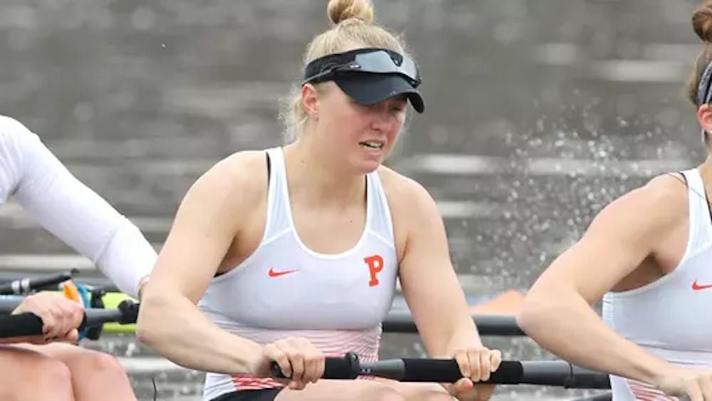 Woman in white and orange rows boat with person in front and behind her 