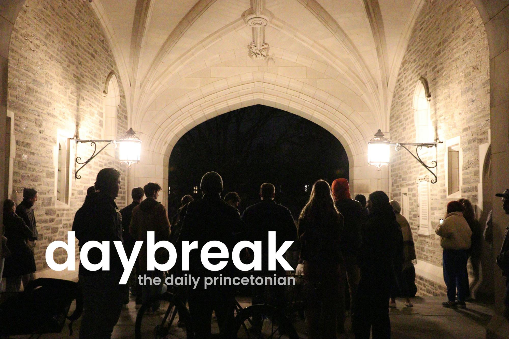 A dimly lit archway with two bright lights on each side. In the middle there are people in a circle, singing. In the foreground, a logo says "Daybreak: the daily princetonian"