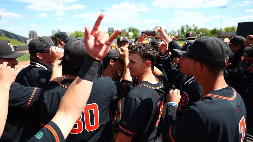 Players in black jerseys huddle together.