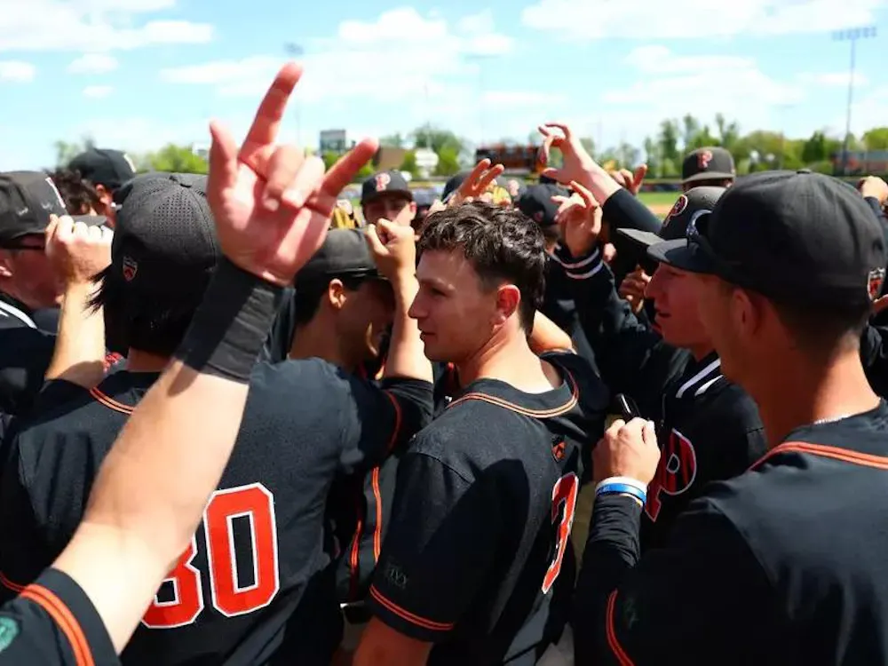 Players in black jerseys huddle together.