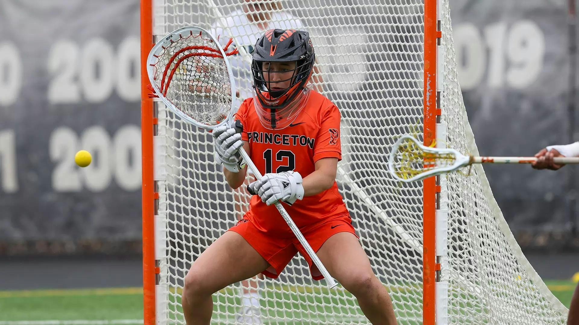 Princeton goalie stands in goal with stick raised.