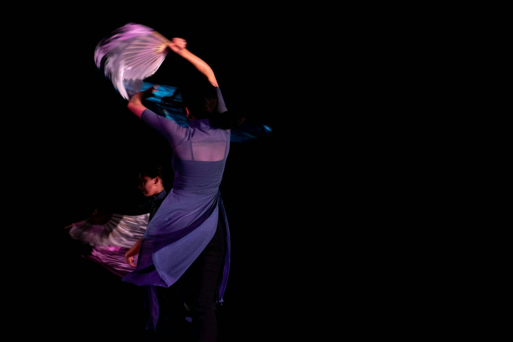 A dancer in a purple outfit twists mid-performance.