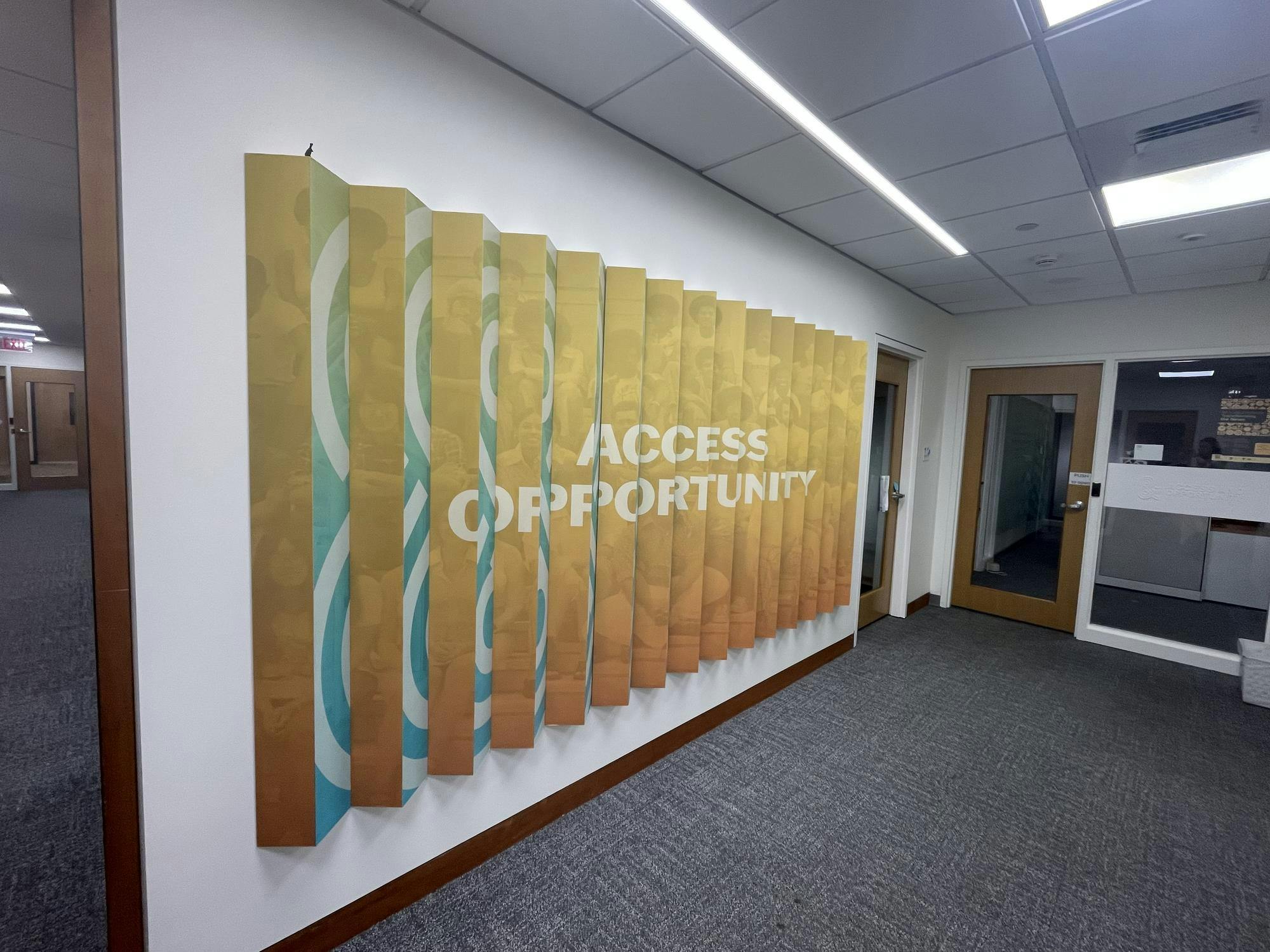 orange and blue sign in an office-like space with the words "access" and "opportunity" 