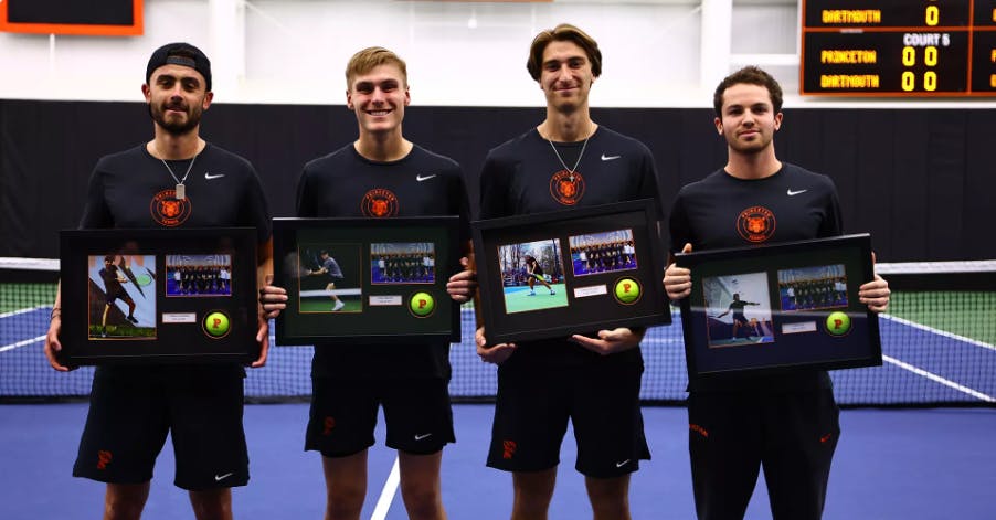 Four Princeton men’s tennis on senior day posing in front of a net.