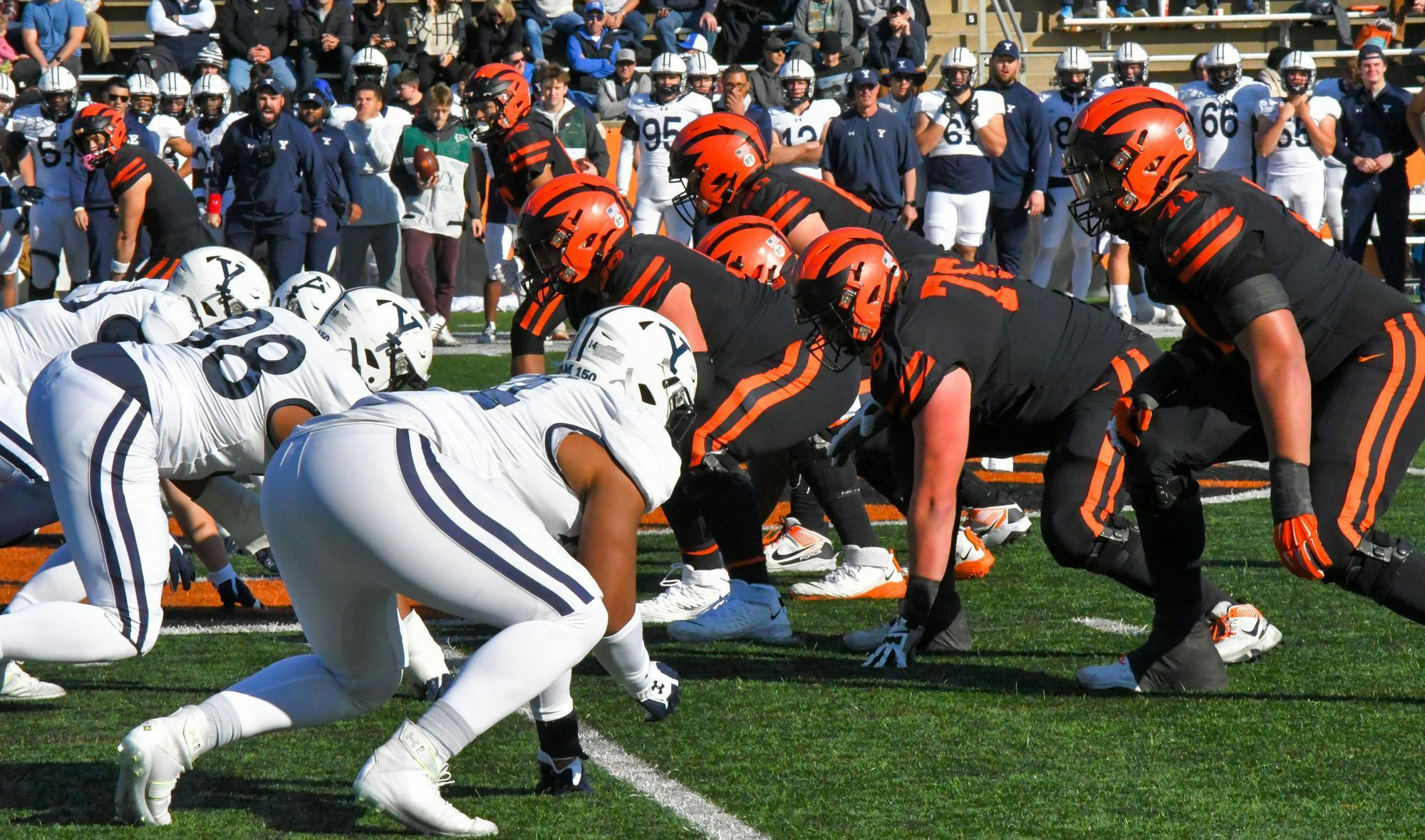 Yale football players on the left and Princeton football players on the right get in position to start the next play.