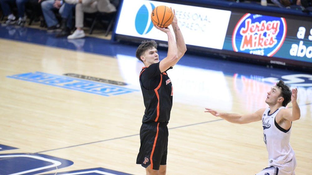 Man in black and orange jersey shoots a basketball