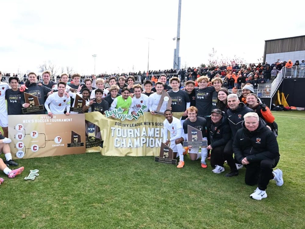 Big team and coaches celebrating win on soccer field, posing for photo.