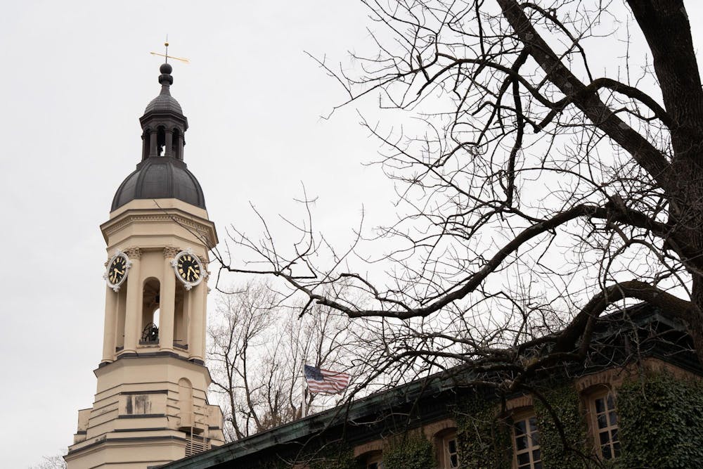 A building with a bell tower on the left side and an extension on the right. A tree with no leaves is in the foreground.