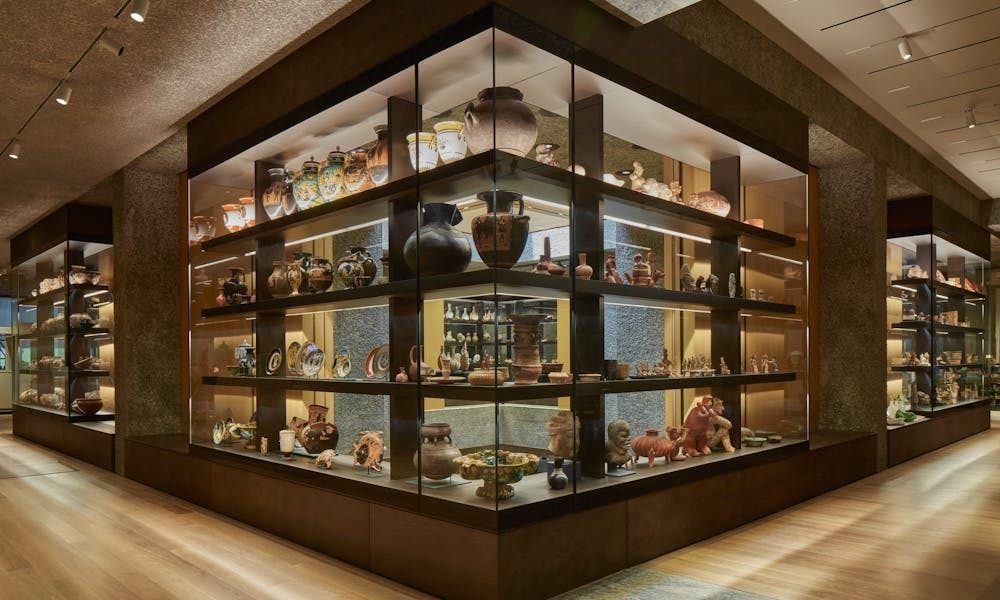 Vitrinas integradas que contienen muchos floreros, boles y otros objetos en estantes.