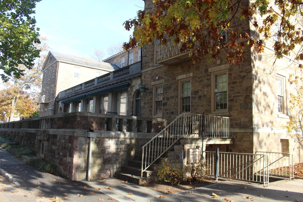 A stone building with an elevated patio on a blue-skied day.