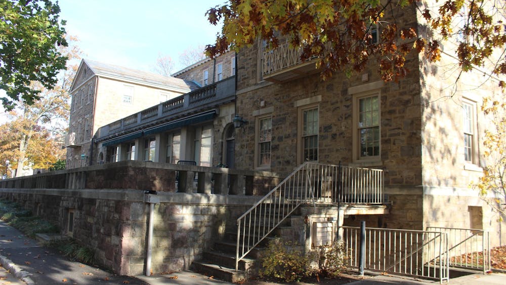 A stone building with an elevated patio on a blue-skied day.