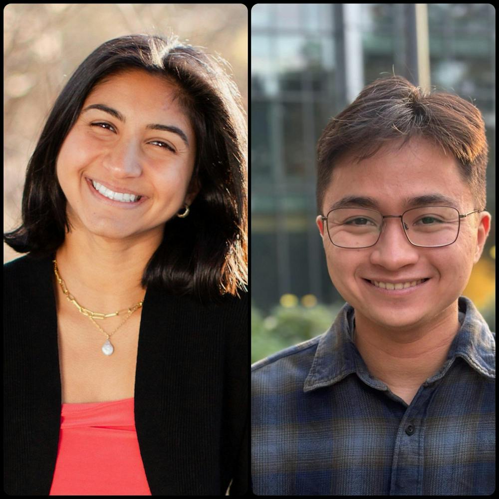 A woman with a short bob and a man with glasses smile at the camera.