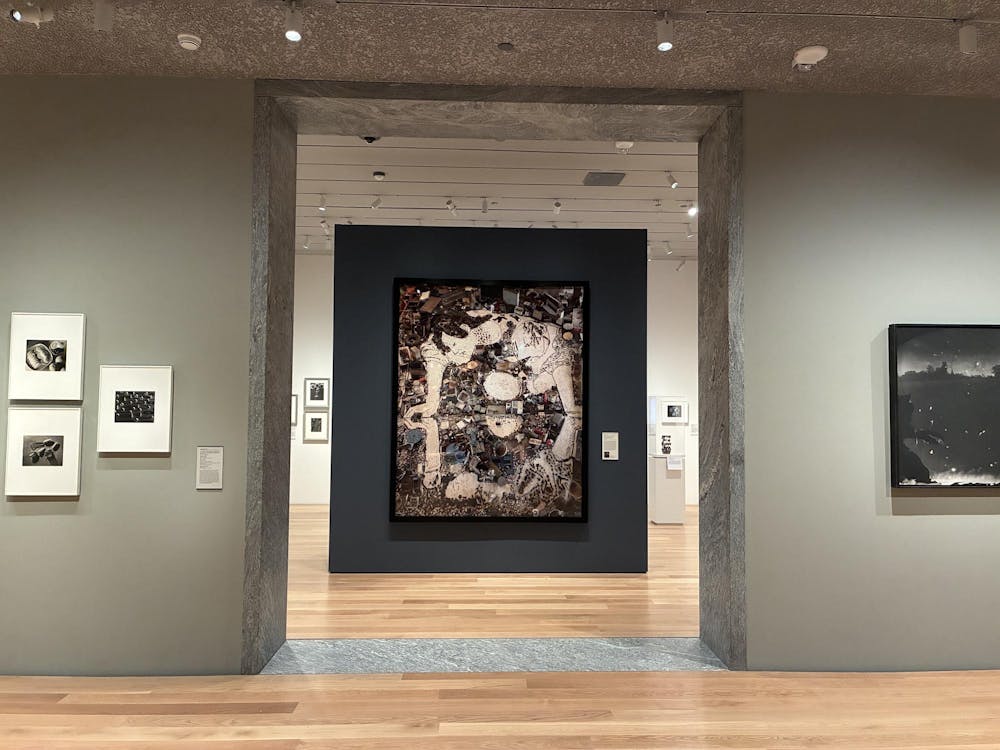 A collage of photographs displaying a person leaning over water hangs in the center of a doorway.
