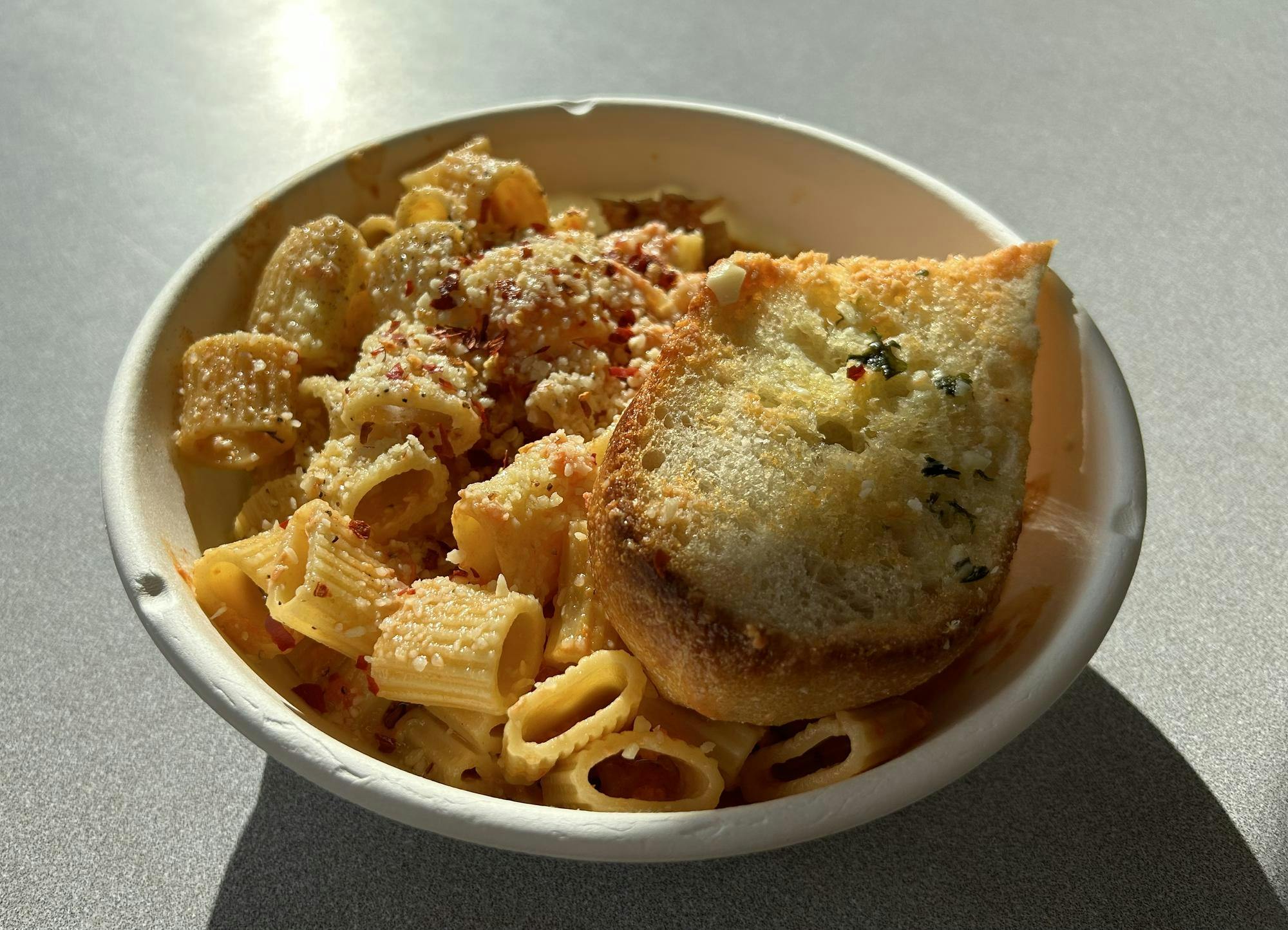 Vodka-sauce pasta with a slice of garlic bread. 