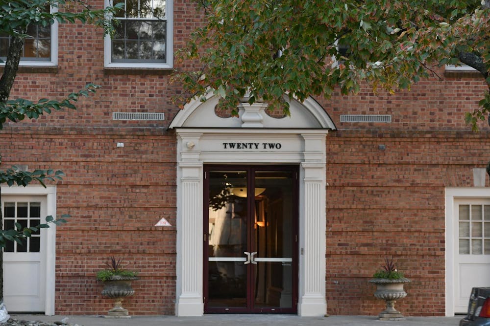 A brick building with a white doorway bearing the address "twenty two."