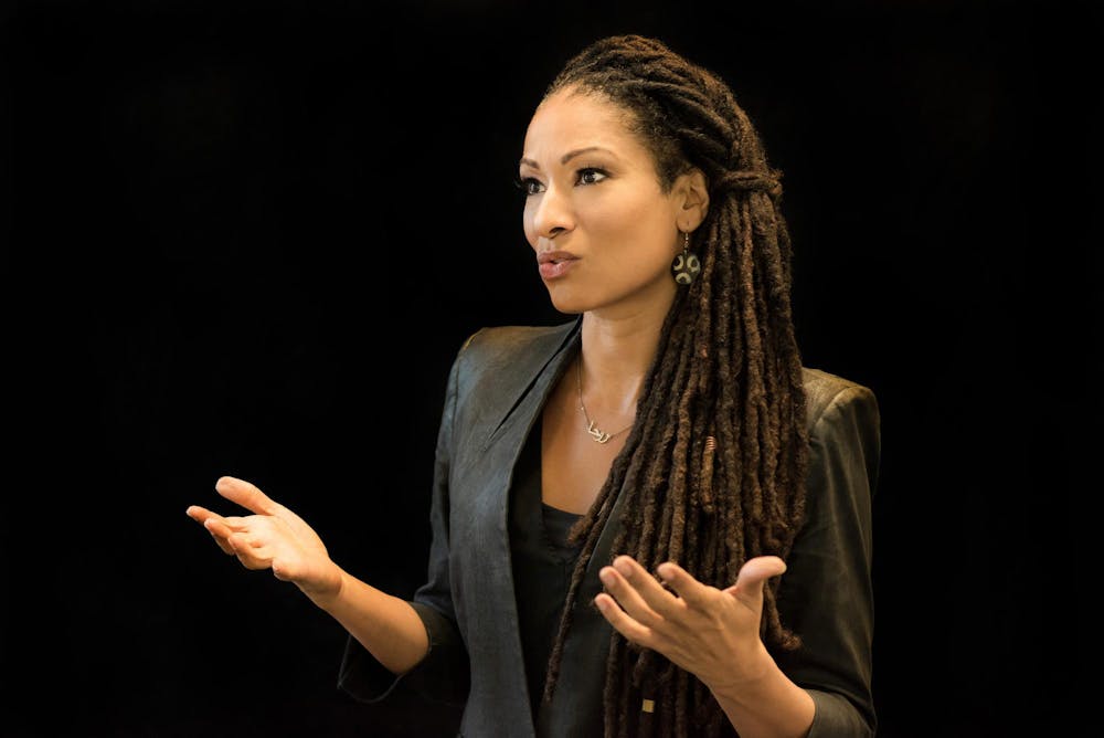 A woman gestures with her hands as she speaks during a talk.