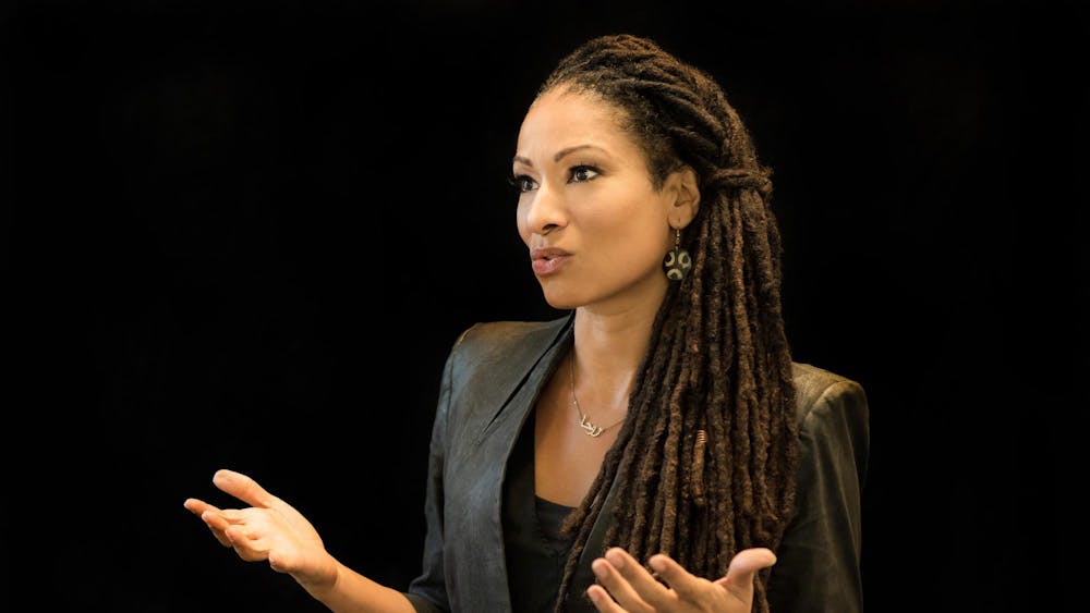 A woman gestures with her hands as she speaks during a talk.