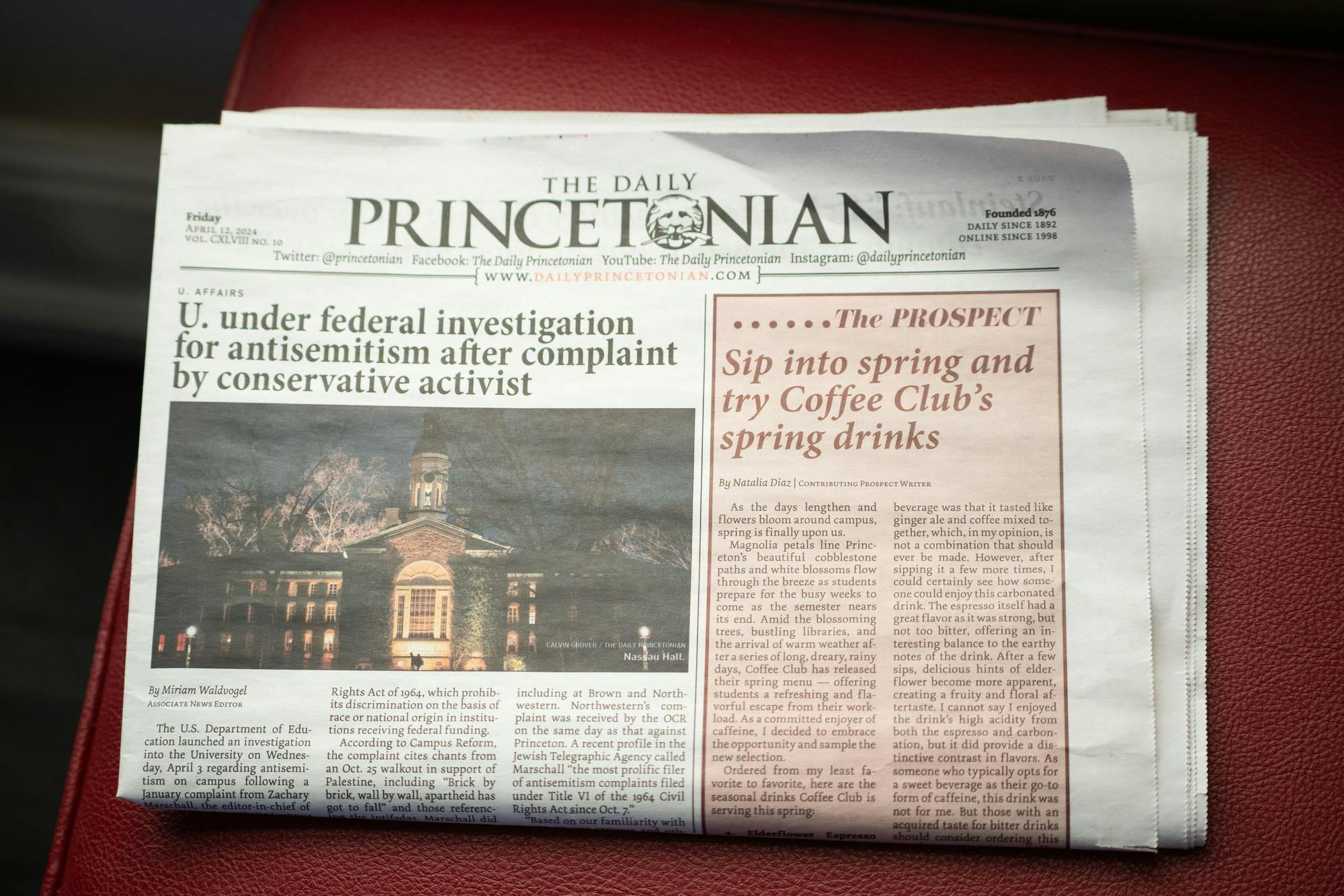 A print copy of the newspaper with a stock photo of Nassau Hall over an article titled “U. under federal investigation for antisemitism after complaint by conservative activist.”