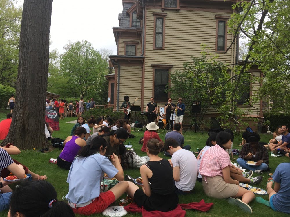 Students sitting, eating, and listening to live music at Yardparties