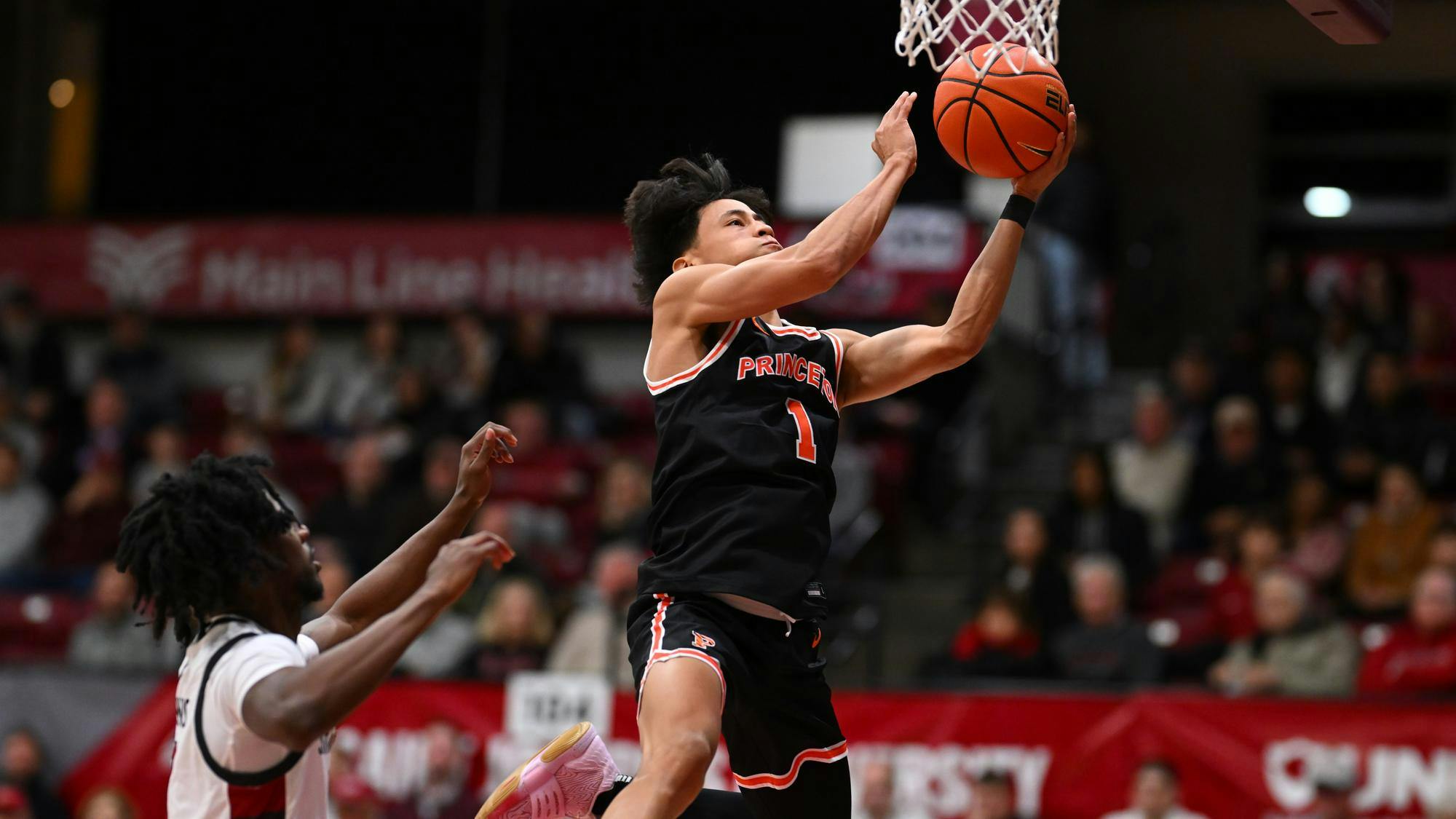 Man doing layup with basketball.
