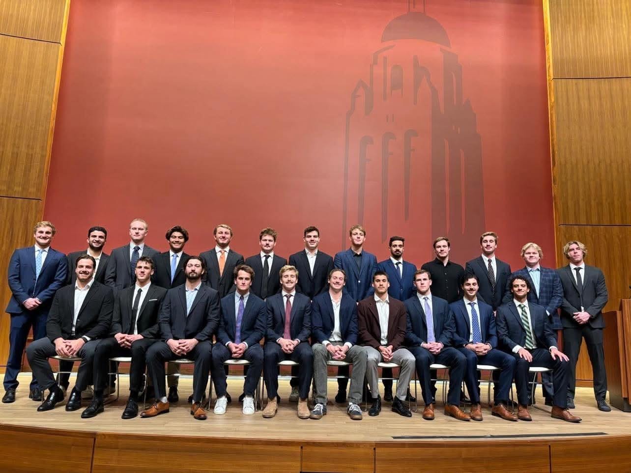 Men in suits pose in two lines.